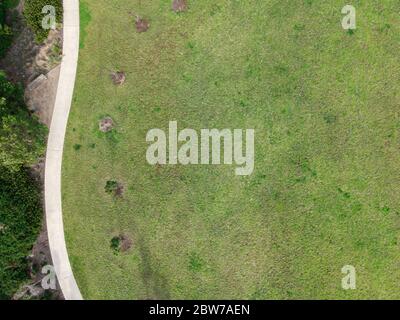 Vue aérienne du nouveau parc de banlieue avec pelouse verte arbustes chemin banquette Banque D'Images