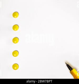 Une feuille de papier blanche avec des tablettes jaunes au lieu de la numérotation et un stylo orange sur le bord de la feuille. Copier l'espace. Banque D'Images