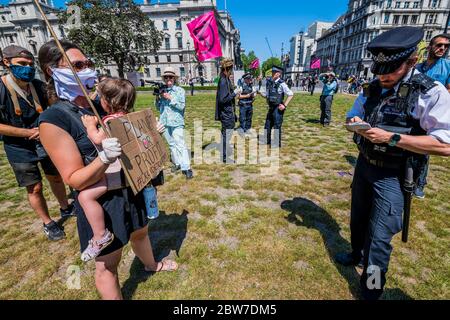 Une mère et son enfant de 3 ans sont menacés d'amende mais, après une longue discussion, continuer - dès qu'ils arrivent, la police se met à menacer les premières amendes puis à arrêter (en partant du principe qu'il s'agit d'un rassemblement d'un isolement à l'isolement, Même s'ils sont tous à plus de 2 m d'intervalle) s'ils ne quittent pas l'hôtel - extinction la rébellion tient une protestation silencieuse et socialement distancée pendant une heure sur la place du Parlement. Ils veulent exprimer leur mécontentement à l'égard de «l'incompétence du gouvernement et exiger une Assemblée des citoyens sur la reprise de Covid-19» comme ils croient que «les institutions politiques en place ne sont pas capables o Banque D'Images