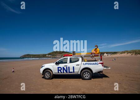 Les gardes de vie RNLI reprennent leurs patrouilles sur la plage de Croyde à Devon en portant des EPI avant l'assouplissement de la restriction de verrouillage du coronavirus lundi. Banque D'Images