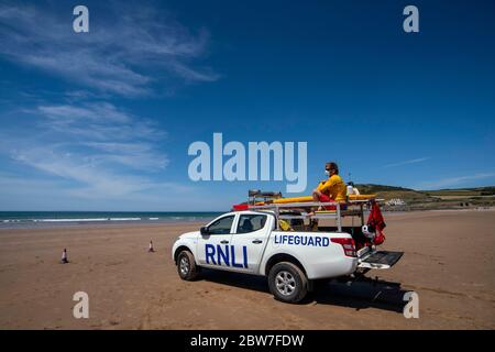 Les gardes de vie RNLI reprennent leurs patrouilles sur la plage de Croyde à Devon en portant des EPI avant l'assouplissement de la restriction de verrouillage du coronavirus lundi. Banque D'Images