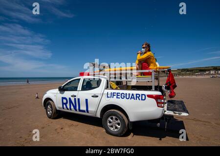 Les gardes de vie RNLI reprennent leurs patrouilles sur la plage de Croyde à Devon en portant des EPI avant l'assouplissement de la restriction de verrouillage du coronavirus lundi. Banque D'Images