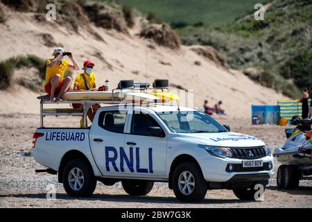 Les gardes de vie RNLI reprennent leurs patrouilles sur la plage de Croyde à Devon en portant des EPI avant l'assouplissement de la restriction de verrouillage du coronavirus lundi. Banque D'Images