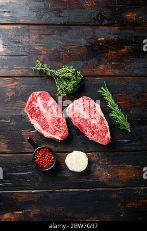 Viande biologique crue Top Blade steaks ou l'Australie Wagyu Oyster lame sur fond de bois foncé vieux vue du dessus. Banque D'Images