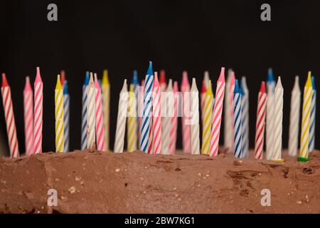 Gâteau d'anniversaire au chocolat avec bougies sur fond sombre Banque D'Images
