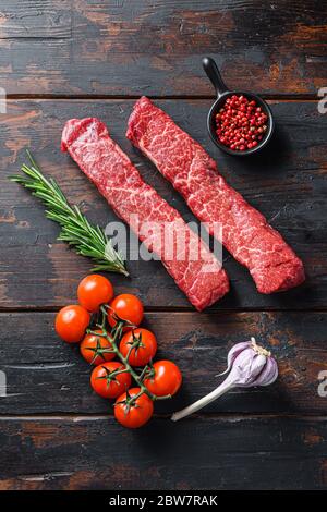 Steak de denver cru ou la lame organique wuth herbes vue du dessus sur la surface de vieux bois de planches. Banque D'Images