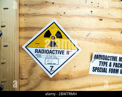Étiquette d'avertissement relative aux matières radioactives à côté de l'emballage en bois standard de transport Banque D'Images