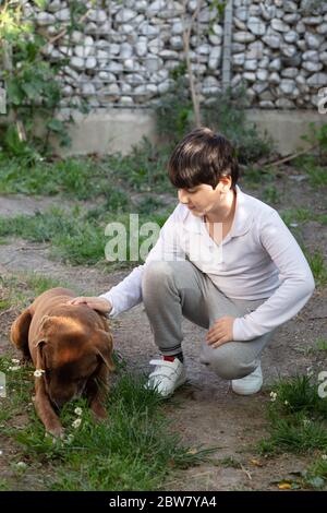 Un enfant joue avec un chien dans le jardin Banque D'Images