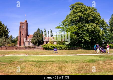 Église Saint Andrews, dans le parcours de golf du club de golf de Rochford Hundred. La tour Tudor et la C16 North Vestry. Trois golfeurs discutant du jeu Banque D'Images