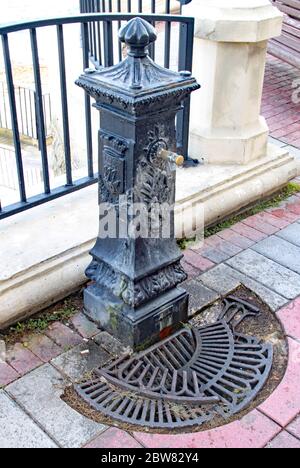 Vieille fontaine usée avec une grille de drainage cassée près de l'esplanade de Sliema, Malte Banque D'Images