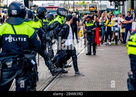 La police de l'unité mobile arrête un manifestant lors d'une manifestation anti-verrouillage.la police de la Haye a arrêté des dizaines de personnes qui se sont rassemblées sur le Koekamp près de la gare centrale de la ville pour manifester contre les mesures d'isolement de confinement du gouvernement visant à contenir la propagation de Covid-19 aux pays-Bas. Banque D'Images