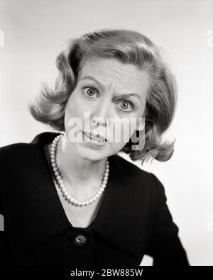 ANNÉES 1950, UNE FEMME EN COLÈRE PORTANT UN HAUT SOMBRE COLLIER EN PERLES REGARDANT LA CAMÉRA - G4589 HAR001 HARS TÊTE ET ÉPAULES À OEIL DE INSECTE AFFLIGÉ EXCITATION IRRITÉE COLÈRE FEMMES D'AFFAIRES COLÈRE COLÈRE HOSTILITÉ À OEIL LARGE IRRITATION ÉMOTION FURIEUSE ÉMOTION IRRITÉE MOYENNE ADULTE FEMME NOIRE ET BLANCHE CAUCASIEN MÉCONTENT HAR001 ORIGINE ETHNIQUE ANCIENNE Banque D'Images