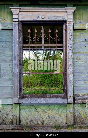 Ancienne fenêtre latidée avec pointes rouillées à une ancienne gare desolate en Autriche Banque D'Images