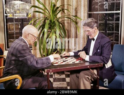 ANNÉES 1960 DEUX HOMMES ÂGÉS JOUANT UN JEU DE DAMES DANS LE SALON AVEC MAISON PLANTE ET CAGE D'OISEAU - KS4261 HAR001 HARS HOMMES BÂTIMENTS DIVERTISSEMENT HOMME SENIOR ADULTE SENIOR OBJECTIFS CAGE DAMES COSTUME ET CRAVATE BONHEUR VIEUX ÂGE OLDSTERS STRATÉGIE GRAND ANGLE OLDSTER ET VIEILLISSEMENT RÉCRÉATION CARTE DE FIERTÉ MAISONS D'OPPORTUNITÉ AÎNÉS CONNEXION GÉRIATRIQUE RÉSIDENCE ÉLÉGANT HOMME ÂGÉ COOPÉRATION RELAXATION SOLUTIONS TOGETHNESS CAUCASIEN ETHNICITÉ HAR001 ANCIEN MODE Banque D'Images