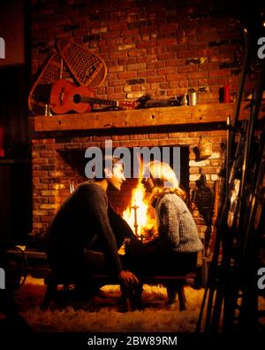 ANNÉES 1960, COUPLE ROMANTIQUE ASSIS DEVANT UNE CHEMINÉE EN BRIQUES DANS SKI LODGE REGARDANT LES AUTRES PORTANT DES CHANDAILS AVEC AMOUR - KW4514 PHT001 HARS CHALEUR RURALE MAISON VIE COPIE ESPACE AMITIÉ DEMI-LONGUEUR FEMMES HOMMES S'OCCUPANT HOMMES HIVER RÊVES BONHEUR LOISIR CONNAISSANCE BASSE ANGLE LOISIRS RELATIONS SWEATERS CONNEXION SHAG TAPIS CHALEUR MANTEAU ÉLÉGANT RAQUETTES ACCESSOIRE PERSONNEL HIVER AFFECTION ÉMOTION ADULTE MOYEN-ADULTE HOMME ADULTE MOYEN-ADULTE FEMME ROMANTIQUE TOGETHERNESS APRES-SKI L'ETHNIE CAUCASIENNE À L'AVANT-MODE Banque D'Images