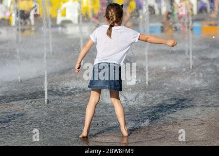 Les enfants se baignent dans la fontaine par une chaude journée d'été Banque D'Images