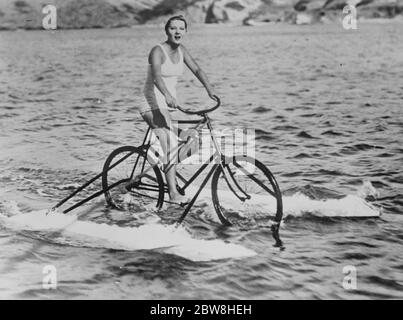 Jolie beauté hollywoodienne présente un nouveau sport nautique . Dorothy Mackail star de beaucoup d'extravaganzas hollywoodiens pédales sans chalantement sur la surface saccadée du Pacifique pendant une vacances du premier National Studio où elle a récemment terminé ' l'Amour Rackett ' une image tout en parlant représentant la vie nocturne de la ' plus jeune ensemble ' . 25 octobre 1929 Banque D'Images