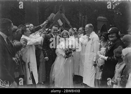 Smithfield marché de la viande célébrité mariée . La mariée et le marié quittant , sous une arche de castors , après la cérémonie , samedi , lorsque M. J Dinsmore et Mlle M Hutchins , se sont mariés à l' église de la Vieille ville , Edmonton . M. Dinsmore est une figure remarquable du marché de la viande de Smithfield, où il est connu affectueusement sous le nom de Jumbo . 19 août 1933 Banque D'Images