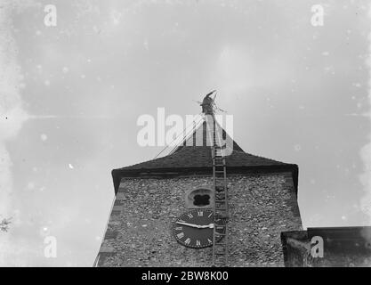 Un steeplejack à l'œuvre au sommet de la tour de l'église St Mary Cray . 1935 . Banque D'Images