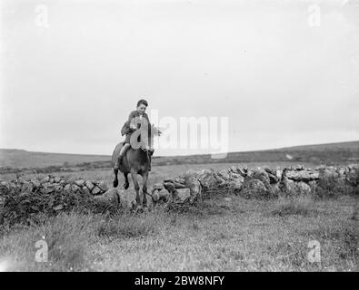 Un jeune garçon fait un cheval de randonnée. 1936 . Banque D'Images