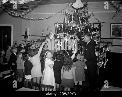 Les enfants autour de l'arbre de Noël à la fête de Noël à l'école de la rue de la moitié , Bexley . 11 décembre 1937 Banque D'Images