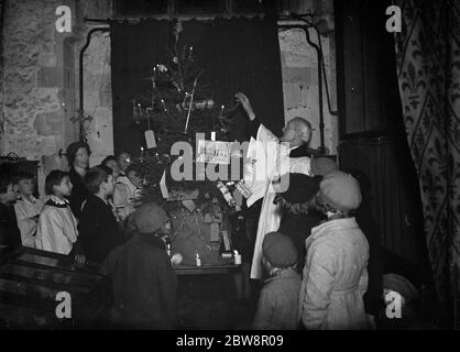 Enfants regardant l'arbre de noël dans l'église paroissiale de Farningham . 1937 Banque D'Images