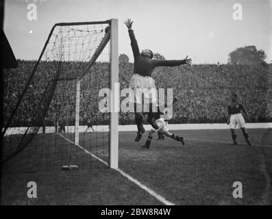 Charlton Athletic football Club contre Leeds United Association football Club . Un gardien de but pointe la balle sur la barre transversale . 1938 Banque D'Images