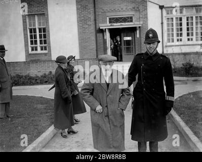 M. Jackson quitte le bureau de vote après avoir voté et reçu la main d'un sympathique gendarme de la police . 22 novembre 1935 Banque D'Images