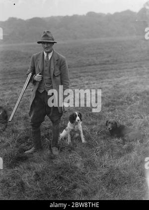 Le gardien de chasse M. Barrett , pose avec un fusil de chasse au bras à côté de ses chiens d'armes à feu . 1936 Banque D'Images