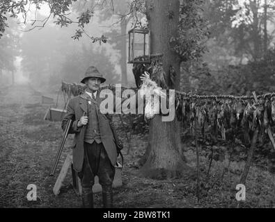 Le gardien de chasse , M. Barrett , pose avec un faucon qu'il a tué . 1936 Banque D'Images