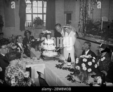 Le mariage de M. John Topham et de Mlle Muriel Haken . Les jeunes mariés ont coupé le gâteau au petit déjeuner de mariage. 1938 Banque D'Images