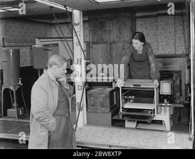 Un camion Bedford appartenant à Vack Industries Ltd de Kingston upon Thames , Londres . Le camion a été converti en salle d'exposition mobile pour son appareil à combustion d'huile. Le côté du camion s'ouvre pour révéler les appareils domestiques . Une femme donne une démonstration . 1937 . Banque D'Images