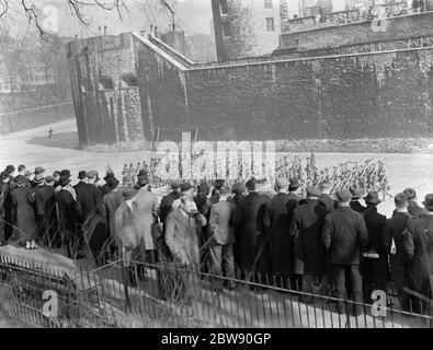 Hommes regardant à travers les rampes aux soldats en marche à l'extérieur de la Tour de Londres . . 1937 Banque D'Images