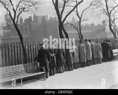 Hommes regardant à travers les rampes aux soldats en marche à l'extérieur de la Tour de Londres . . 1937 Banque D'Images