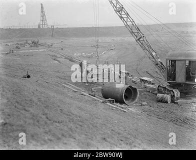 Ouvriers utilisant une grue pour la construction du tunnel de Dartford . Les travaux commencent à l'entrée . 1937 Banque D'Images