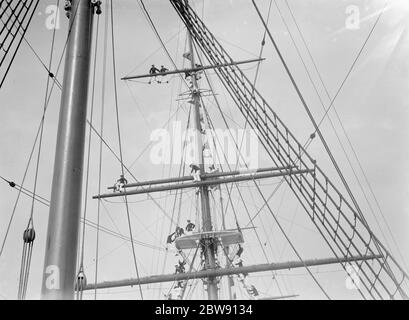 Les cadets du Thames Nautical Training College de Greenhithe , Kent , se tiennent sur le gréement du navire d'entraînement HMS Worcester . Ils essaient d'obtenir une meilleure vue de la course de bateaux de formation de Worcester . 1937 Banque D'Images