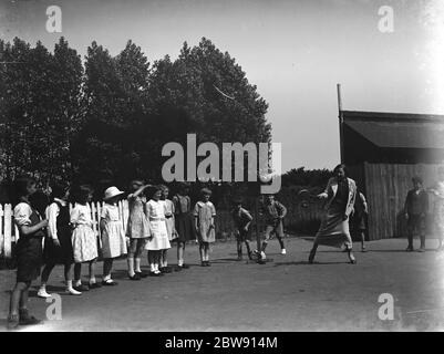 Une femme jouant du stoolball avec des enfants à Hartley , Kent . 1937 Banque D'Images