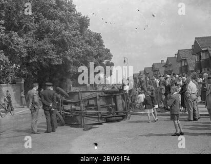 Une foule se rassemble autour d'une voiture écrasée sur la rue de la moitié à Sidcup , Kent . 1939 Banque D'Images