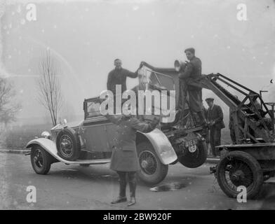 Les Rolls Royce endommagés étant remorqués après qu'il s'est écrasé avec un camion à Bexley , dans le Kent . AA patrolman dirige le trafic . 28 février 1936 Banque D'Images