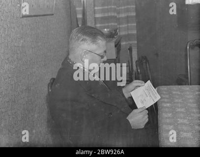 Un homme lisant un reçu remis par un officier allemand au capitaine Patrick G Dove du pétrolier Africa Shell qui déclare que le sextant du capitaine et d'autres instruments de navigation ont été confisqués . Le pétrolier a été coulé par le croiseur allemand Admiral Graf Spee qui a été à son tour sabordé après la défaite de la bataille de la plaque de rivière aux mains de navires britanniques. 16 novembre 1939 Banque D'Images