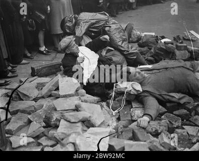 Exercice de précaution en RAID aérien sur Old Kent Road à Londres . Les spectateurs regardent comme les "victimes" sont tendaient à pendant l'exercice . 1939 . Banque D'Images