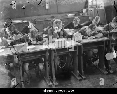 Enfants à l'école à Sidcup , Kent , pendant la guerre . Ici, ils sont dans une leçon avec leurs masques à gaz à portée de main en cas de bombardement . 1939 Banque D'Images