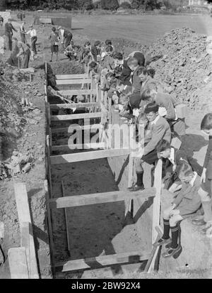 Enfants à l'école à Sidcup , Kent , pendant la guerre . Ici, ils regardent des ouvriers creuser une tranchée pour un abri DE R P . 1939 Banque D'Images