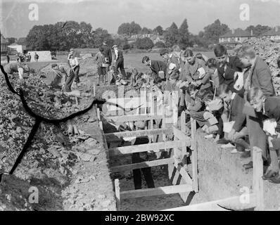 Enfants à l'école à Sidcup , Kent , pendant la guerre . Ici, ils regardent des ouvriers creuser une tranchée pour un abri DE R P . 1939 Banque D'Images