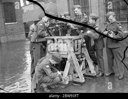 Les nouveaux cadets de l'air de la Croix se tiennent autour d'un moteur d'avion en apprenant sur ses mécanismes . 1939 Banque D'Images