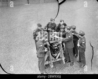 Les nouveaux cadets de l'air de la Croix se tiennent autour d'un moteur d'avion en apprenant sur ses mécanismes . 1939 Banque D'Images