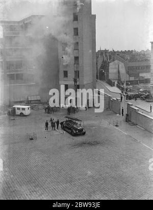 Un exposition de la brigade de pompiers de Londres à Lambeth , Londres. Les pompiers utilisent des échelles d'extension pour monter un grand bâtiment pendant la démonstration . 1939 Banque D'Images
