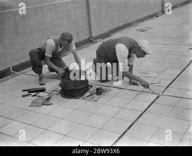 Travailleurs de Val de travers Asphalt Limited , une entreprise de pavage , travaillant sur un toit à Greenwich , Londres . 1938 Banque D'Images