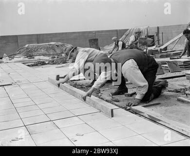 Travailleurs de Val de travers Asphalt Limited , une entreprise de pavage , travaillant sur un toit à Greenwich , Londres . 1938 Banque D'Images