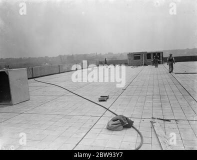 Travailleurs de Val de travers Asphalt Limited , une entreprise de pavage , travaillant sur un toit à Greenwich , Londres . 1938 Banque D'Images